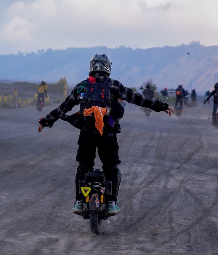 Rider with arms out crossing the caldera floor