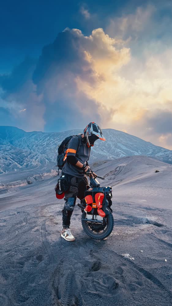 Rider crossing the volcanic ash plain below Mount Bromo