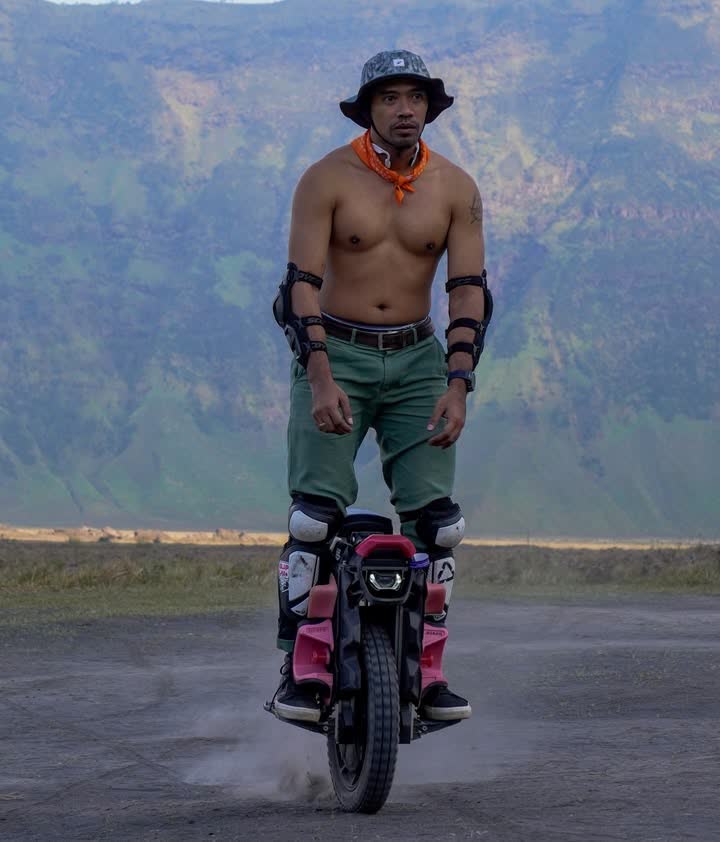 Shirtless rider in a bucket hat on the caldera rim