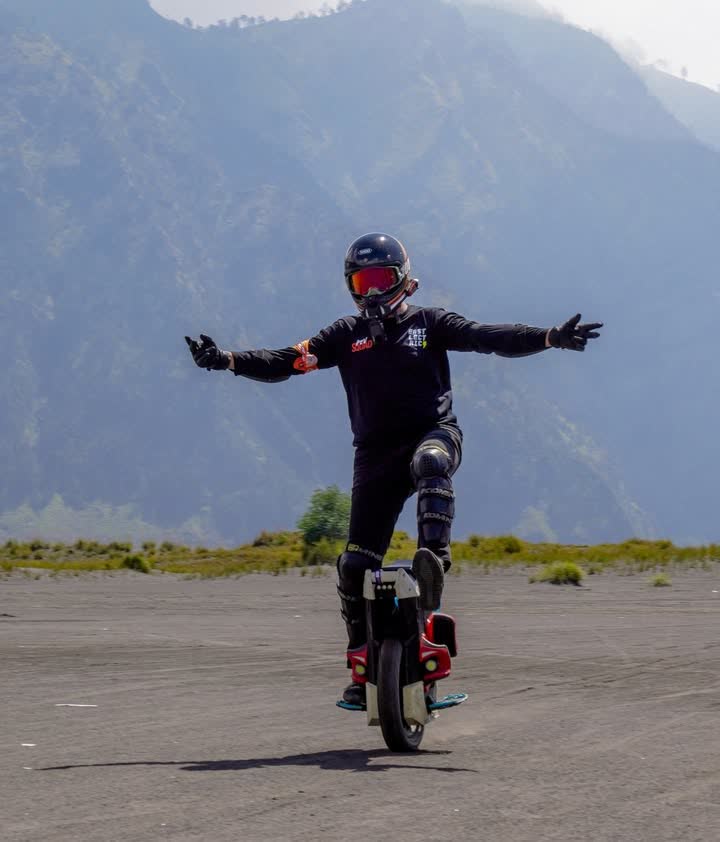 Rider with both arms wide against the mountain backdrop