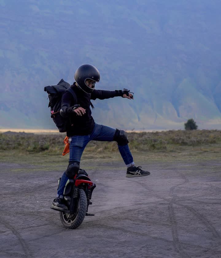 Rider with one leg extended mid-turn on the sand