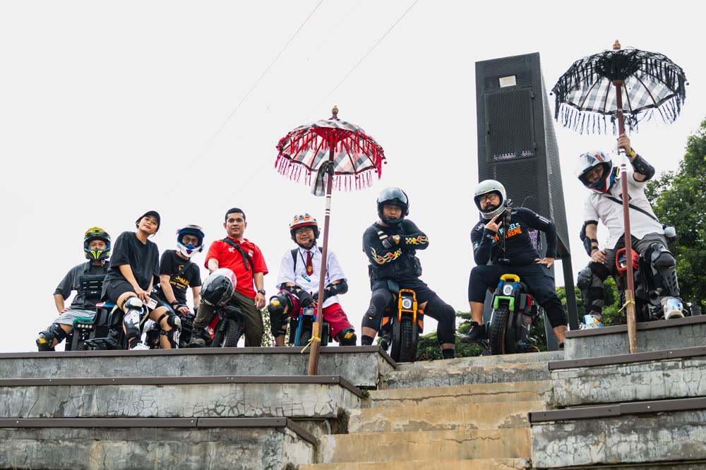 Riders posed on temple steps between ceremonial umbrellas