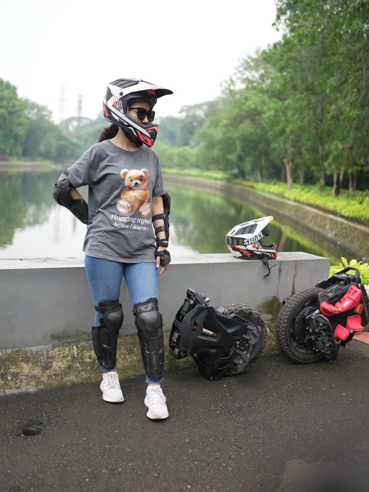 Rider standing with helmet on beside the water at Ragunan