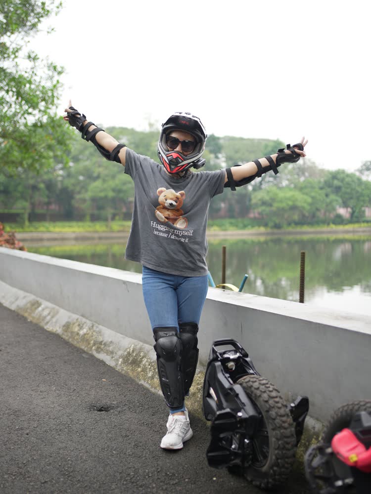 Rider with arms spread wide beside the water