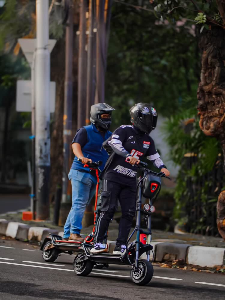 Two scooter riders sharing a lane