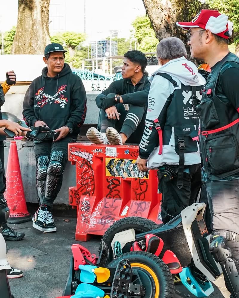 Riders gathered around crates at a roadside coffee stop