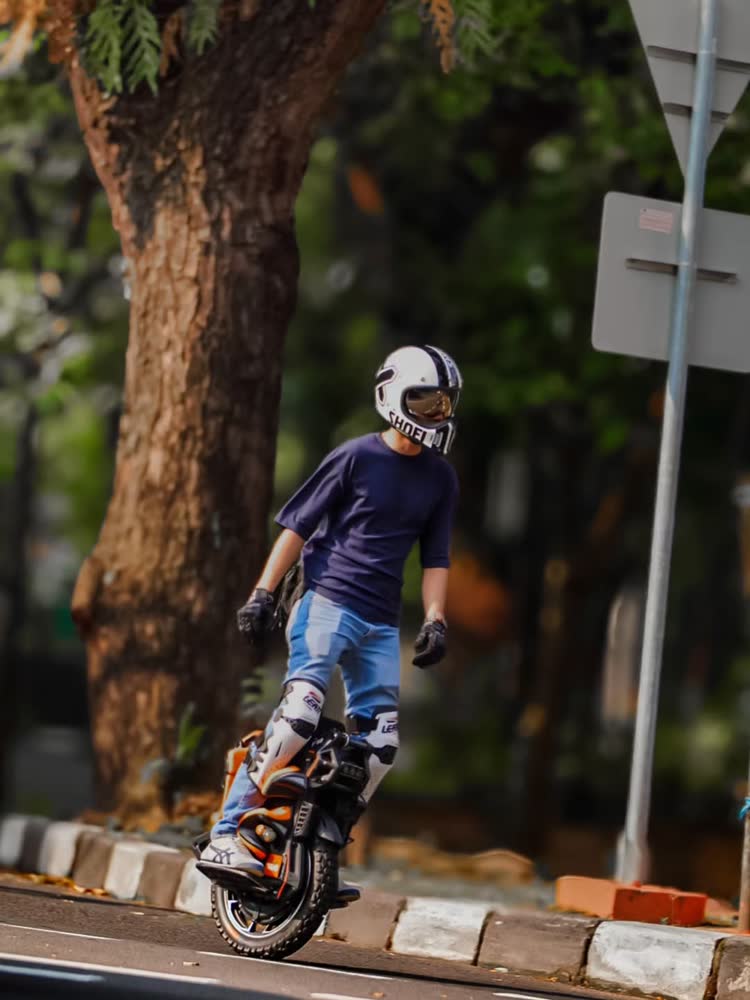 Rider passing beneath a large roadside tree