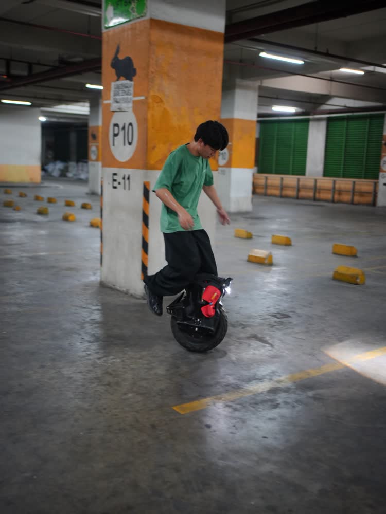 Rider on an EUC beside a numbered parking pillar