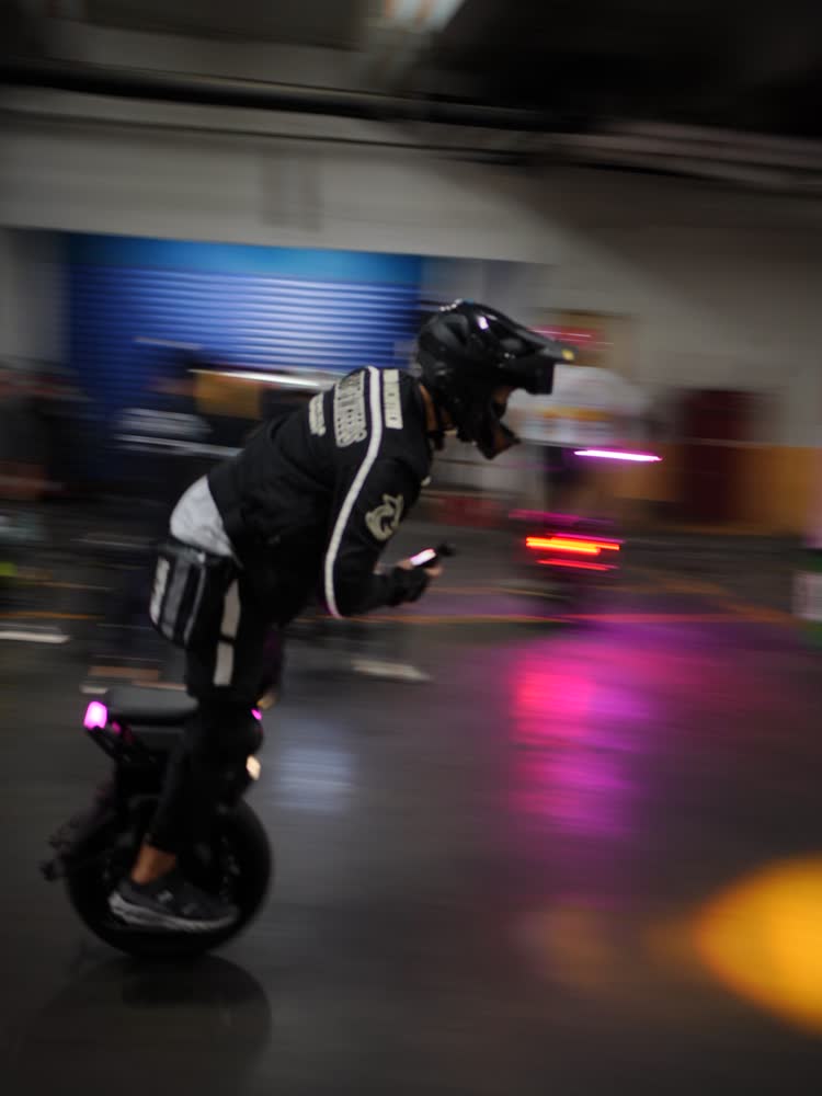 Motion-blurred rider streaking through a parking garage
