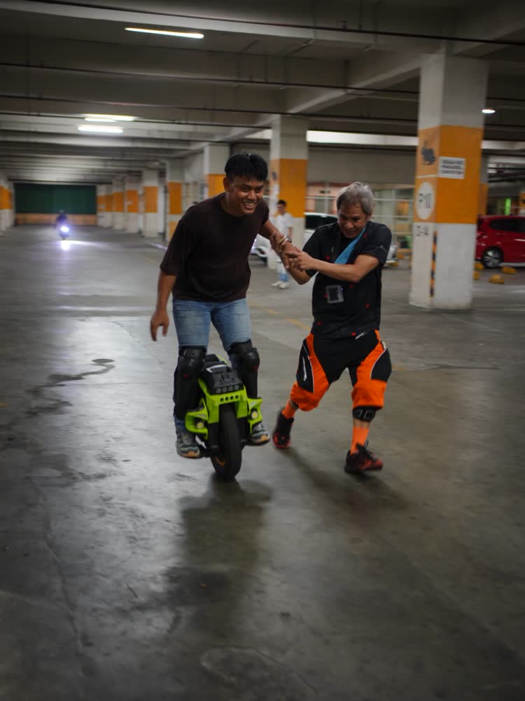 One rider steadying another who is learning to balance