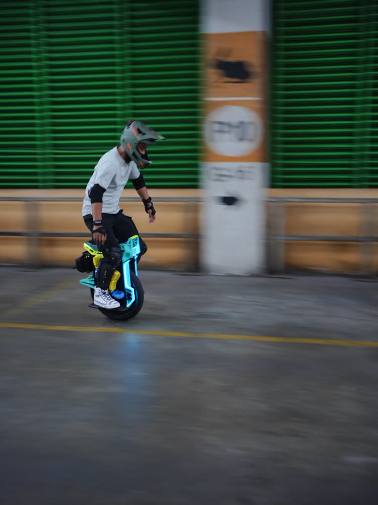 Rider with teal underglow against green shutters