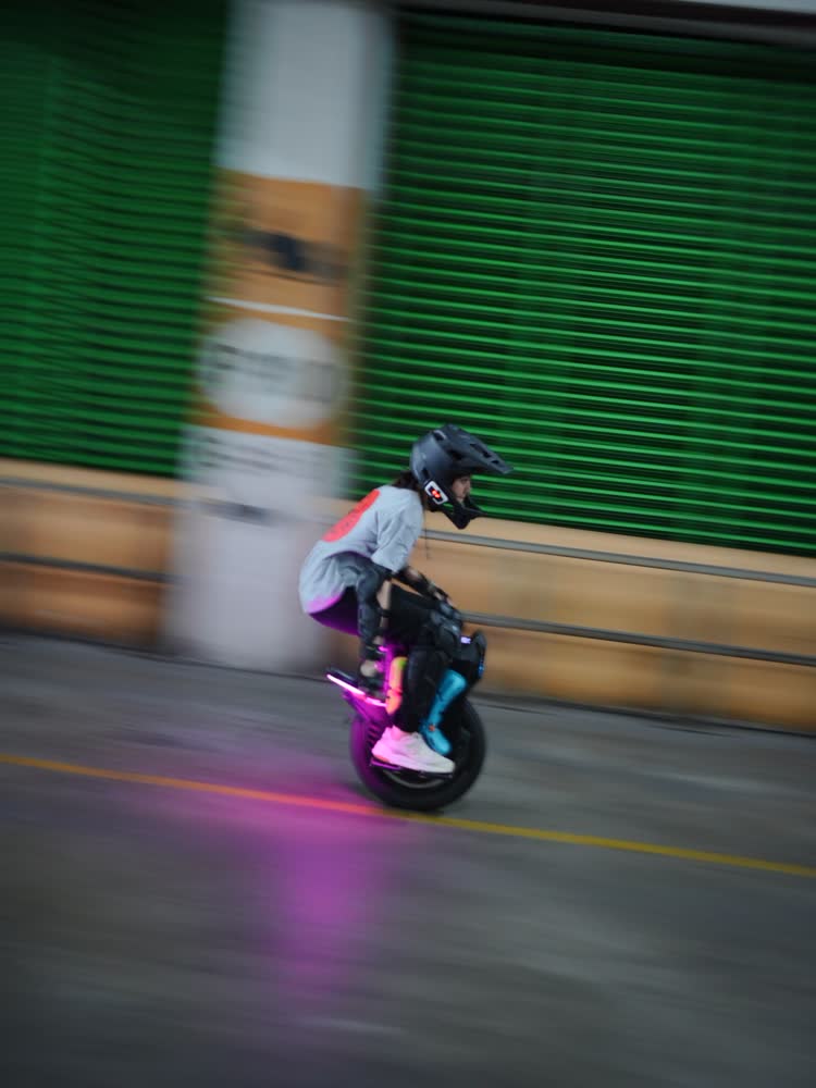 Rider trailing pink light through the garage