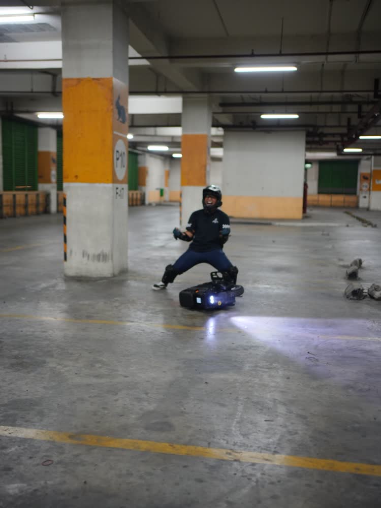 Wide view of an empty parking level with a single distant rider