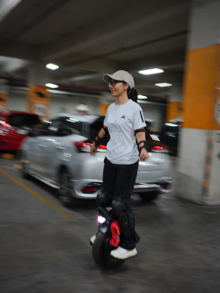 Rider coasting slowly past a parked car