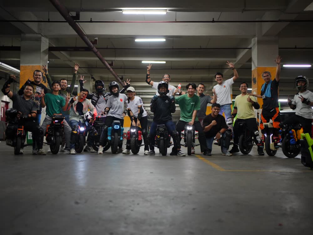 Large group of PEV Squad riders posed together in the parking garage