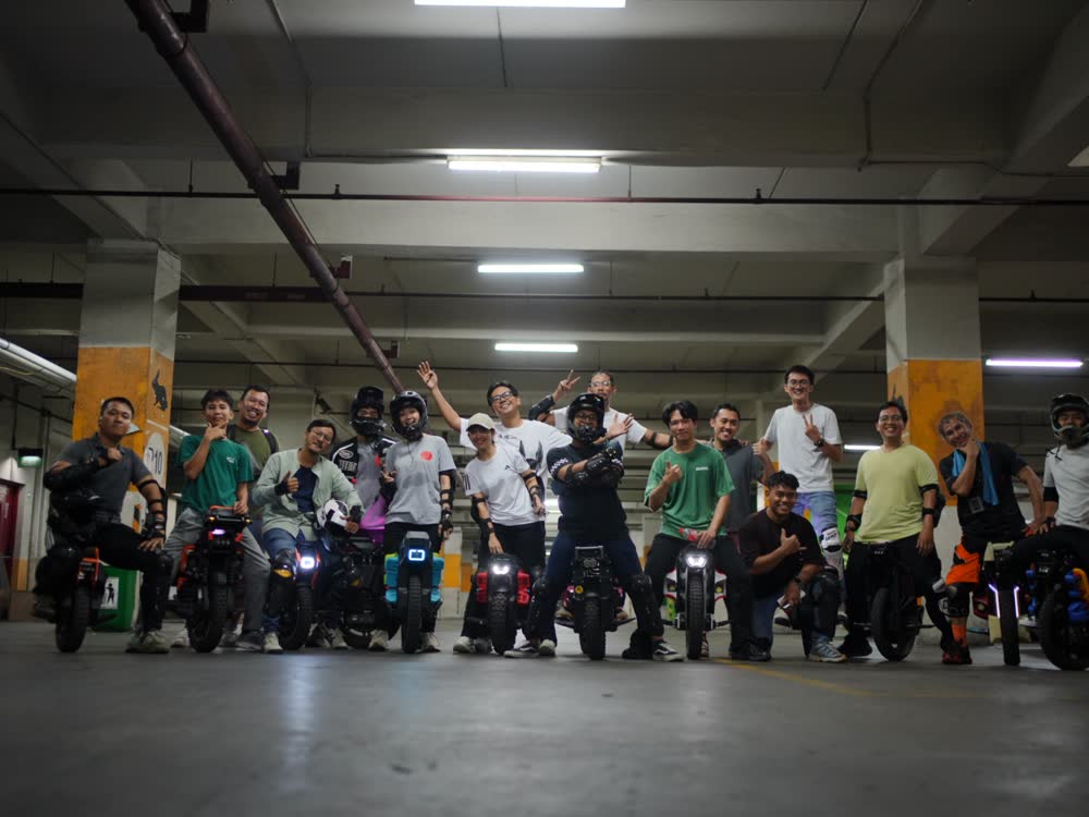 Riders lined up across the garage for a group photo