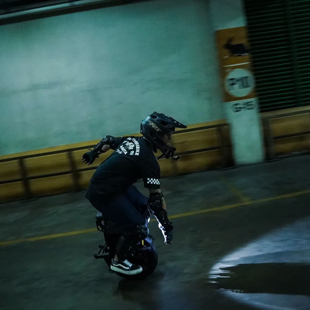 Rider crouched into a carve lit by teal light