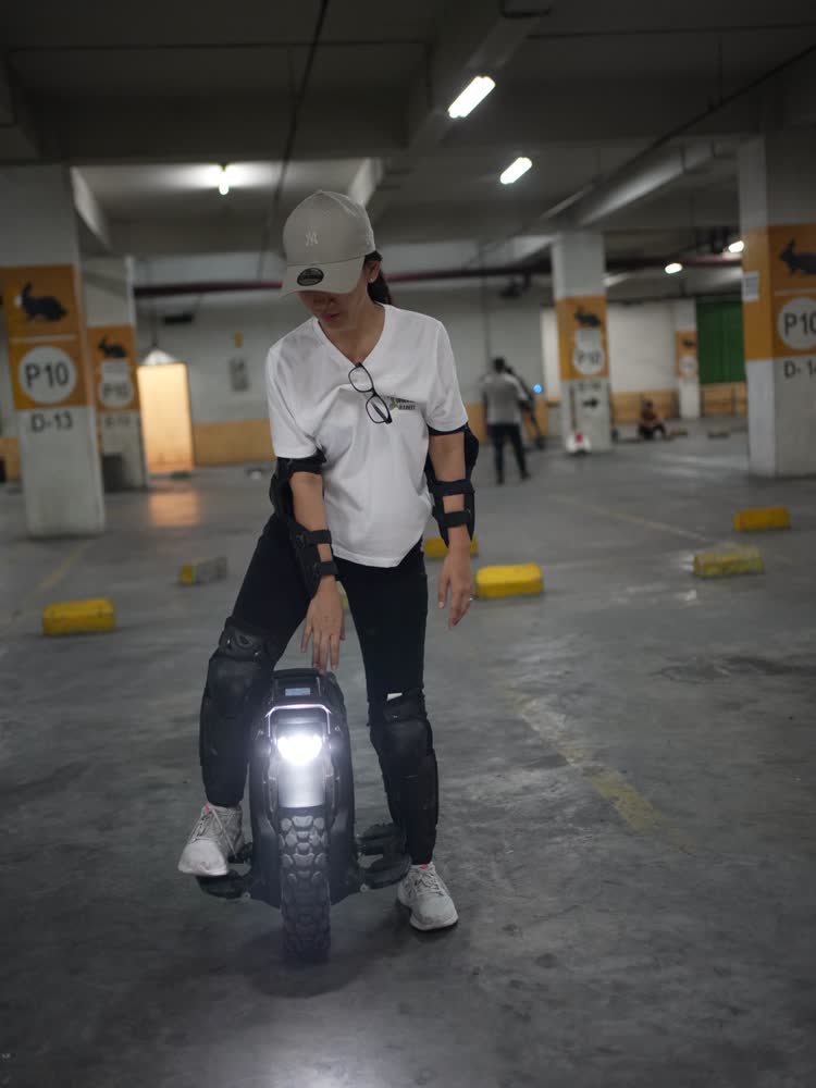 Rider in a white tee on an EUC under the P10 sign