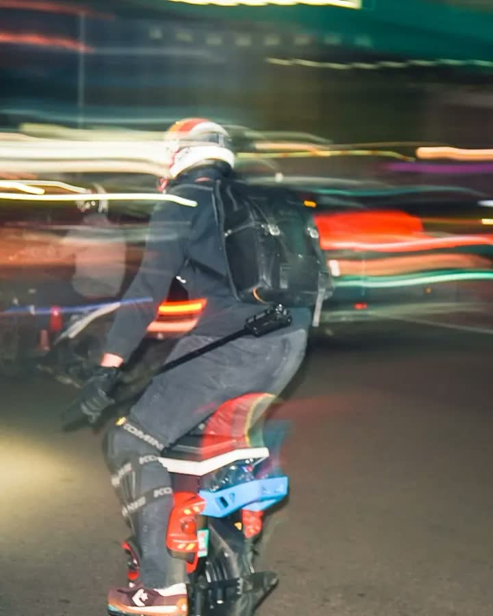 Long-exposure photo of a rider surrounded by streaking light trails